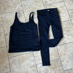 Svart tränings sätt från 157 - Säljer en svart tränings sätt från 157 i storlek medium. Toppen har smala axelband och är tillverkad i ett stretchigt syntetmaterial som andas. Perfekt för gymmet eller annan träning. Snygg och enkel design.