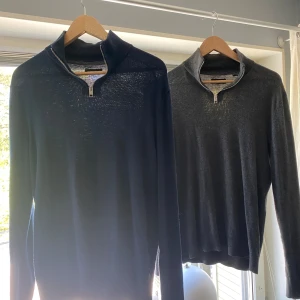 (2 FÖR 1) Mörkblå och grå halvzip-tröjor från Jack & Jones - Två stilrena halvzip-tröjor från Jack & Jones i mörkblått och grått. Tröjorna har lång ärm, hög krage med dragkedja och är tillverkade i ett mjukt material som passar perfekt till vardags. Snygg och enkel design, perfekt till sommaren vid kyliga kvällar