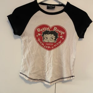 Betty Boop t-shirt med tryck - Säljer en vit och svart t-shirt med korta ärmar från Betty Boop. Köpt på Urban outfitters, använd några ggr. 