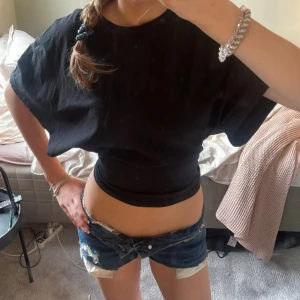 Svart t-shirt från Nelly - Svart t-shirt från Nelly med lös passform och korta ärmar. Enkel och stilren design som passar perfekt till jeans eller shorts. Gjord i mjukt bomullsmaterial för en bekväm känsla hela dagen.