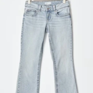 Ljusblå bootcut jeans - Snygga ljusblå jeans med bootcut-modell och klassisk femficksdesign. Jeansen har en lätt tvättad look och normal passform, perfekta för en avslappnad stil. Tillverkade i mjukt denimtyg med dragkedja och knapp framtill.