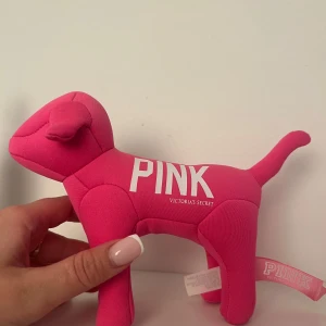 PINK Victoria's Secret plush hund - Supergullig rosa plush-hund från PINK Victoria's Secret med tryck i vitt på sidorna, bland annat årtalet 1986. Perfekt som dekoration eller samlarpryl. Mjuk och formad som en liten hund 
