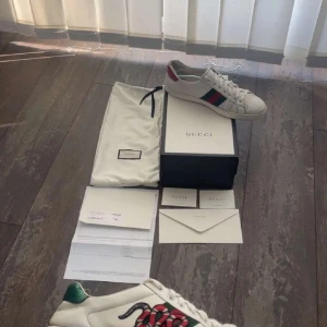 Gucci Ace snake - Gucci Ace sneakers i vitt skinn med ikoniska gröna och röda ränder på sidan och broderad orm. Baksidan har metallicdetaljer i rött och grönt med ormskinnsmönster. Klassisk rund tå, snörning och platt sula. Kommer med originalkartong och dustbag. 6000kr ny mitt pris  1500kr 