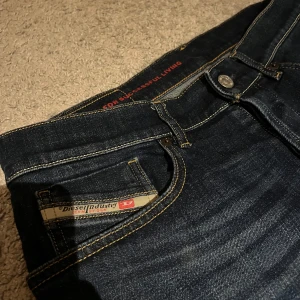 Mörkblå jeans från Diesel - Snygga mörkblå jeans från Diesel med dn diskret logga på fickan. Jeansen har fem fickor, och en stilren, rak passform. Materialet är slitstarkt denim i bomull. Perfekta för dig som gillar en clean och tidlös look. Nypris är ca 1800kr💸. Passar perfekt på mig som är ca 180cm