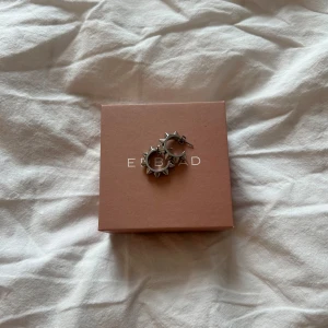 Silvriga örhängen med nitar från Edblad - Coola silvriga hoops från Edblad med markerade nitar runt hela örhänget. De är runda och har en edgy vibe som verkligen sticker ut. Perfekta för dig som vill ha något annorlunda och snyggt i öronen.