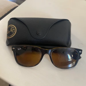 Rayban boyfriend  - Snygga Ray-Ban New Wayfarer RB2132 med brunmelerad båge och bruna glas. Klassisk och tidlös modell med Ray-Ban-logga på sidan. Kommer med original svart fodral. Perfekta för dig som vill ha en cool och ikonisk look. Hör av er vid frågor och funderingar 