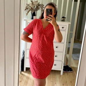 Klänning från M&S - Superfin röd kortklänning från M&S Collection med vita prickar, v-ringning och korta ärmar. Skön och luftig i bomull! Liten i storleken, mer som en M/38/40!🌸