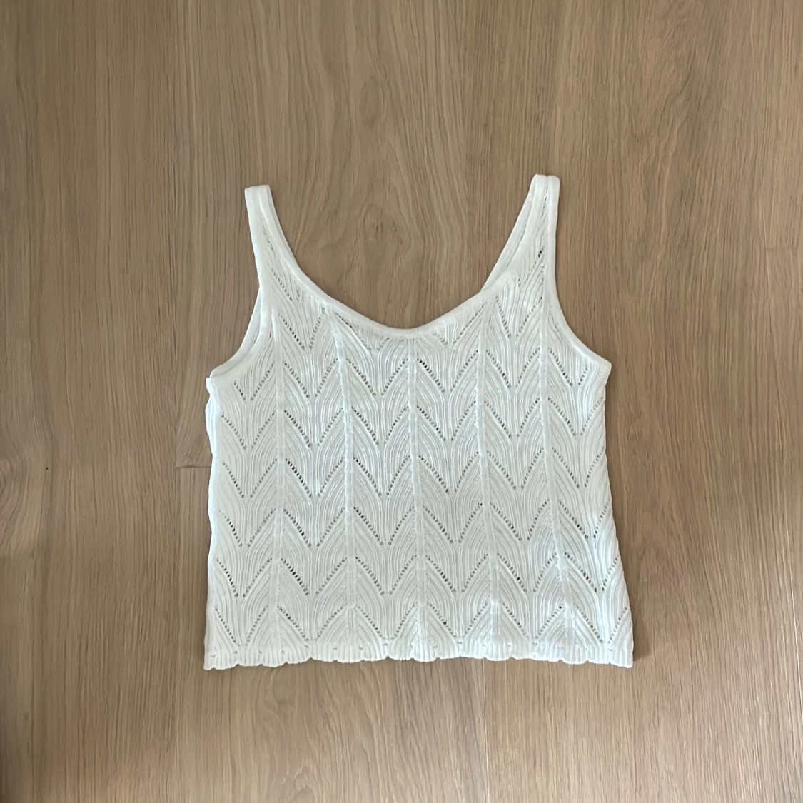 Vit stickad linnetopp med mönster