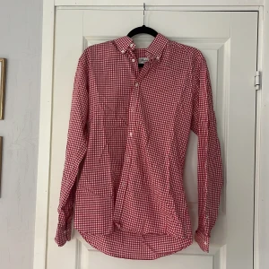 Rödvit rutig skjorta Stenströms Slimline - Snygg röd och vit rutig skjorta från Stenströms i modellen Slimline. Skjortan har klassisk krage med knappar, långa ärmar och vita knappar framtill. Tillverkad i mjuk bomull. Har ett litet hål längst ner där bak men syns knappt. 