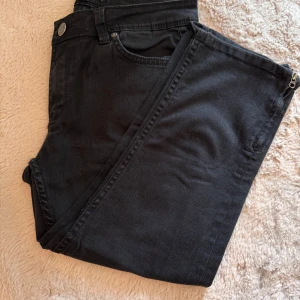 Svarta jeans med dragkedja vid benslut - Snygga svarta jeans med klassisk femficksdesign och coola dragkedjor vid bensluten. Perfekta för dig som gillar en stilren look med en twist.