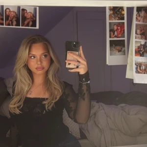 Svart festtopp mesharm +paljetter - Svart topp från Gina. Genomskinliga mesh-armar. Täckt i paljettrosor. Använd 2 gånger. Nypris 430, säljer för 200kr. Strl M, passar även S.