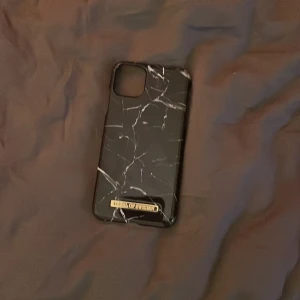 Mobilskal i svart vitt med marmor mönster och med fina guld detaljer på - Ett fint skal för iPhone 14 och uppåt. Vad jag vet har den inga repor jag köpte på Sellpy men råka beställa fel storlek då jag har iPhone 12