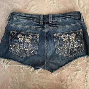 Lågmidjade jeansshorts med rhinestones - Lågmidjade jeansshorts med rhinestones på bakfickorna🌟De är tyvärr för små därför säljer jag💓midjemått 35cm rakt över och pris är diskuterbart🌸