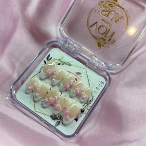 SugarSakura (XS);Medium Almond - Snygga gelé press on-naglar i en medium mandelform med fransk tipp. Naglarna är nude med vita toppar och dekorerade med 3D-blommor i rosa och små pärlor. Perfekt för dig som vill ha en söt och trendig look utan att gå till salong. Kommer i storlek XS: 14 mm, 11 mm, 11,5 mm, 10 mm, 8 mm 