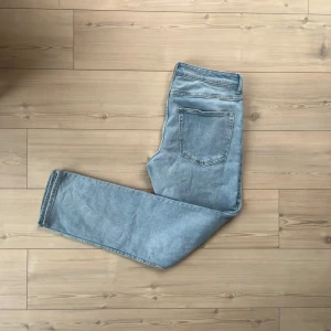 Ljusblå straight jeans från H&M, 32/34 - Säljer ett par ljusblå jeans från H&M med straight regular fit. Klassisk femficksmodell med normal passform och raka ben. Jeansen är i mjuk bomullsdenim och har en enkel, clean look utan slitningar eller detaljer.