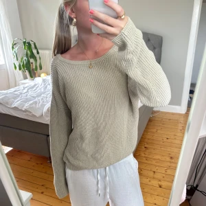 Beige stickad tröja med vid hals - Säljer en skön beige stickad tröja med avslappnad passform.