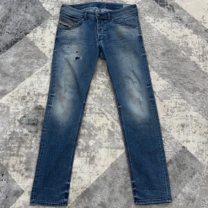 Diesel jeans slitna - Snygga blå jeans från Diesel, modell Belther. Väldigt bra skick. Jeansen har en slim passform, klassisk och slitna detaljer framtill. Tillverkade i mjukt denim med lätt stretch för extra komfort. Storlek 32. Priset går att diskutera.