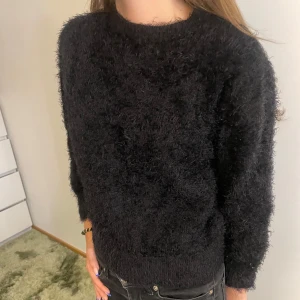 Svart fluffig stickad tröja - Mysig svart stickad tröja med fluffig textur och rund halsringning. Är i storlek 11-12 år och passar på så vis inte mig i ärmarna utan har då använt den som trekvartsärmad. Den har en relaxed passform som ger en chill  men samtidigt snygg vibe.🙏🏼 Pris kan diskuteras