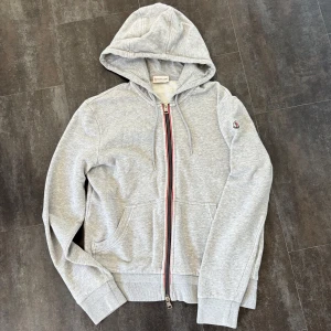 Moncler Zip hoodie - Tja, säljer denna riktigt schyssta grå Moncler zip hoodien i grymt skick! Size M och inga defekter. Självklart äkta. Skriv vid funderingar!