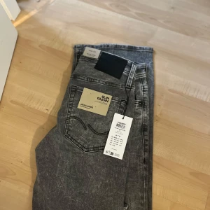 Slim Glenn grå jeans Jack & Jones - Slim Glenn jeans från Jack & Jones i tvättad grå färg. Modellen är slim fit och allt sitter kvar på, de är helt nya köpte den och den var försmå. Skriv vid funderingar 