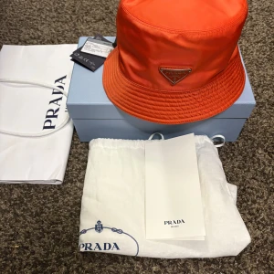 Prada Bucket Hat Helt Ny - Prada Re-Nylon Bucket Hat, helt ny med tags, box, dustbag, kvitto och påse. Storlek M