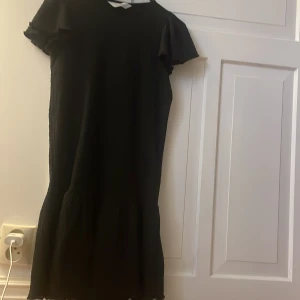 Svart kortklänning från H&M - Svart klänning från hm, med lite volanger, använd få gånger.
