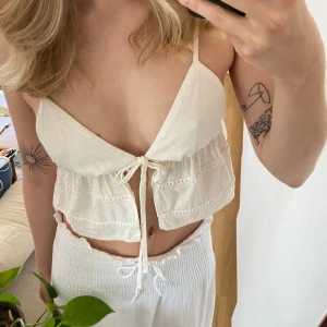 Gullig topp - Fint linne med broderi detaljer och knyte längst fram. Banden går att justera och rosetten går att knyta om. Jag har XS men den är väldigt elastisk så passar nog S bra