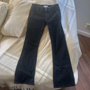 Svarta bootcut jeans från Gina Tricot - Svarta jeans från Gina Tricot i bootcut-modell med snygga detaljer på bakfickorna. Byxorna har normal passform och är tillverkade i ett mjukt bomullsmaterial. Klassisk femficksdesign och knappstängning framtill. (Med midje justering)