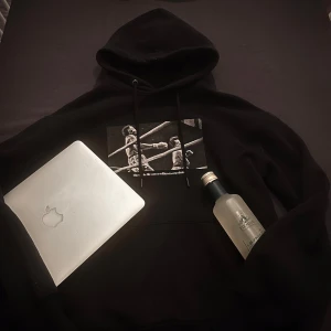 Svart hoodie med Rocky Balboa-tryck - Svart hoodie med tryck av boxningsscen framtill och stor text 'ROCKY BALBOA THE ITALIAN STALLION' på ryggen. Huva med dragsko och klassisk känguruficka. Perfekt för dig som vill ha något till de sköna sommar kvällarna!