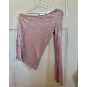 Rosa glittrig asymmetrisk topp - Säljer en rosa glittrig topp med asymmetrisk skärning och lång ärm. 💕