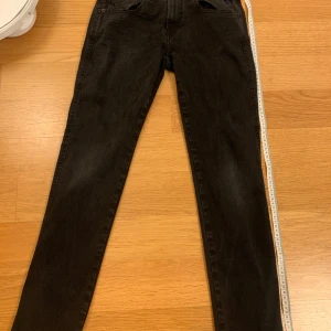 Svarta Replay Hyperflex Anbass jeans ny pris 1700kr - Säljer ett par svarta Replay Hyperflex Anbass jeans med smal passform. Jeansen har klassisk femficksdesign, blå Replay-broderi på fickan och stretchigt material för extra komfort. Perfekta för dig som gillar stilrena och bekväma jeans.