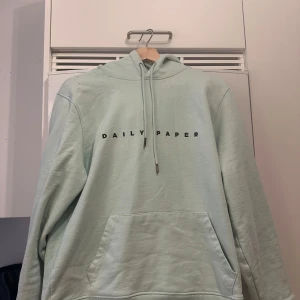 Ljusblå Daily Paper hoodie - Säljer en ljusblå hoodie från Daily Paper med svart text på bröstet. Storlek M. Använt en gång så helt fläckfri 