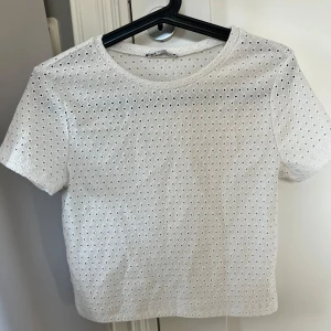 Vit topp från Zara - Säljer en söt vit topp med ”hålmönster” från Zara. Använd fåtal gånger, pris kan diskuteras🤍