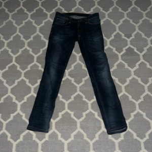 Mörkblå jeans från Nudie Jeans - Säljer dessa väldigt feta nudie jeans! Skick 9 ut av 10. Tror dom är omsyda !!Vid några funderingar eller frågor kontakta oss🙌