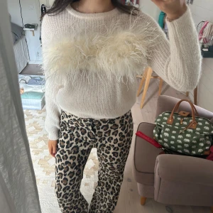 Vit stickad tröja med fjäderdetalj - Säljer denna vita stickade tröja med äkta fjädrar från Massimo Dutti i storlek S. ALDRIG använd, är alltså som helt sprillans ny. Köparen står för frakten. Kvar så länge det ej står såld 