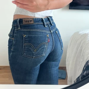 Levis 627 Straight jeans blå - Säljer ett par klassiska blå Levis 627 Straight jeans med normal passform. Jeansen har fem fickor, gul kontrastsöm och Levis ikoniska läderpatch bak i midjan. Är 168cm lång och dem går ner hela vägen.