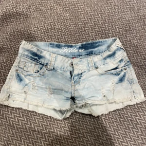 Ljusblå lågmidjade jeansshorts från Fishbone - Säljer ett par ljusblå jeansshorts från Fishbone med slitna detaljer och fransig kant. Shortsen är lågmidjade. De är i storlek S. 