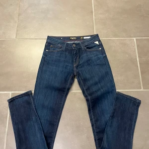 Mörkblå jeans från Replay - Klassiska mörkblå jeans från replay med fem fickor och raka ben. Byxorna har normal passform och är tillverkade i slitstarkt denimtyg. Perfekta för en avslappnad stil.