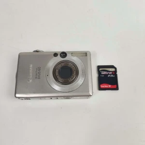 Canon IXUS 60 Digitalkamera - Perfekt för den som vill ha en enkel och smidig kamera att ta bilder med. Kameran har en zoomobjektiv och tar bilder med 6.0 megapixlar. Ett minneskort ingår. Fungerar som den ska. Medföljer batteri och minneskort saknar dock laddare. Se bilder för skick.
