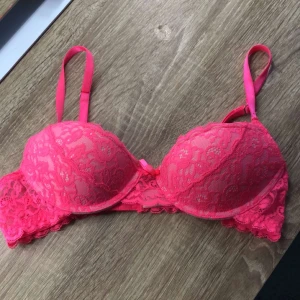 Rosa spets-bh  - Säljer en snygg rosa bh från Gina Tricot med spetsdetaljer och vadderade kupor. 