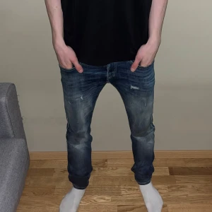 Replay jeans - Säljer ett par blå jeans från Replay med snygga slitningar och en riktigt snygg design. Jeansen är slim i passformen, perfekt till vardags. Tydliga Replay-detaljer på bakfickan och etikett i midjan. Riktigt bra skick och knappt använda☑️