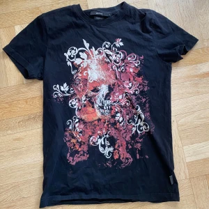 Affliction type t shirt  - Svart t-shirt från Blend med ett stort tryck av en dödskalle i rött, vitt och orange samt dekorativa vita mönster 😼 storlek s 