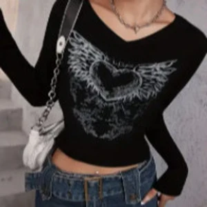 Svart croptop  - Hej jag säljer en svart y2k croppad  topp. Den har v-ringad hals och sitter löst på mig då materialet är skönt och stretchigt.. Den ger lite edgy vibes:-) 