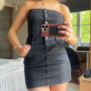 Jeansklänning - Snygg kort jeansklänning med knappar framtill och fickor på sidorna. 