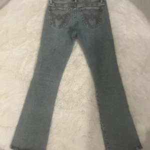 Ljusblå jeans med broderade bakfickor - Säljer ett par ljusblå jeans från Perfect Jeans med snygga bruna broderier på bakfickorna. Jeansen har klassisk femficksdesign, normal passform och raka ben. Perfekta till vardags för en avslappnad stil.
