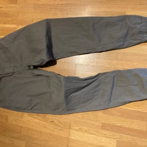  stretch chinos från 157 - Khaki chinos från 157 i stretchigt material. Byxorna har resår vid benen och i midjan . 