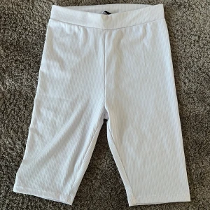 Vita cykelshorts  - Säljer ett par vita cykelshorts. De har en hög midja och är lite räfflade i tyget. 