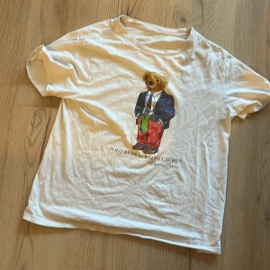 Ralph Lauren Polo Bear T-Shirt - Säljer min vita ralph lauren t-shirt då den inte riktigt kommer till användning längre, tröjan är i rätt slitet skick och säljs därmed super billigt. Försöker få sålt så snabbt som möjligt så hör av er om ni är intresserade 🙌