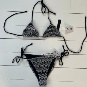 Bikini NA-KD - Superfin bikini från NA-KD i missoni liknande mönster💕 Den har aldrig blivit använd och har alla prislappar kvar samt trosskyddet i underdelen. Överdelen är triangelformad och underdelen knyts i sidorna. Tredje bilden visar bikinin bakifrån. Båda delarna är i storlek S. Originalpris 405kr