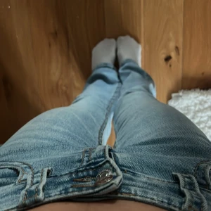 Ljusblå bootcut jeans från Gina Tricot - Säljer ett par ljusblå jeans från Gina Tricot med bootcut-modell. Jeansen har klassiska fem fickor, knapp- och dragkedjestängning samt lätt slitning på låren. Perfekta för dig som gillar en retroinspirerad look.